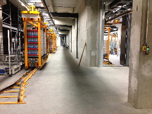 Automated overhead monorail system transfers beverage pallets horizontally in Sweden